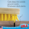 Close-up deck scrub broom with yellow bristles reaching deep between deck planks; text: Gets into ground cracks