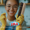 Smiling woman in yellow gloves holding Lola hand scrub brush in kitchen, American owned and operated company since 1969