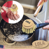 Lola large Tampico dish brush scrubbing a greasy black skillet at the sink, with inset showing hand-held use without handle