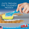 Sudser wand with yellow-green sponge head scrubbing baked-on food residue off a metal sheet pan, cuts tough messes
