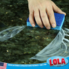 Hand pressing blue cellulose cleaning sponge into soapy dark granite countertop, leaving a clean streak.
