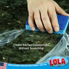 Gloved hand holding Be Clean Be Happy cellulose scrub sponge with soap suds for household cleaning