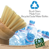 Brush fibers made from recycled soda/water bottles, close-up natural tampico bristle head over crushed plastic bottle with recycling symbol