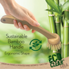 Sustainable bamboo handle ergonomic dish brush held in hand in front of green bamboo stalks with eco recycling symbol